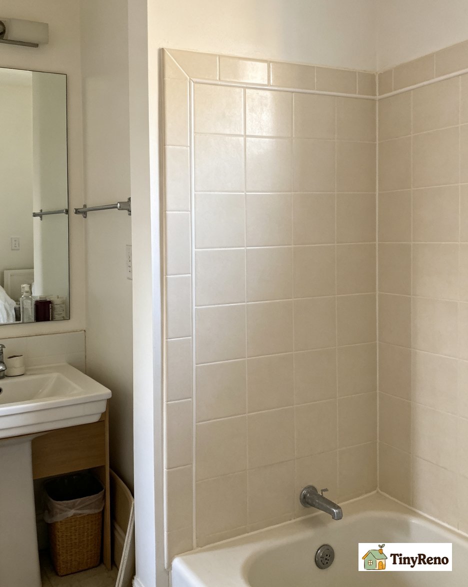 A finished shower with new white grout in the tile seams and mildew resistant caulk in the corner after repair